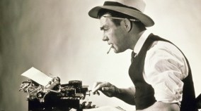 Side profile of a journalist typing on a typewriter